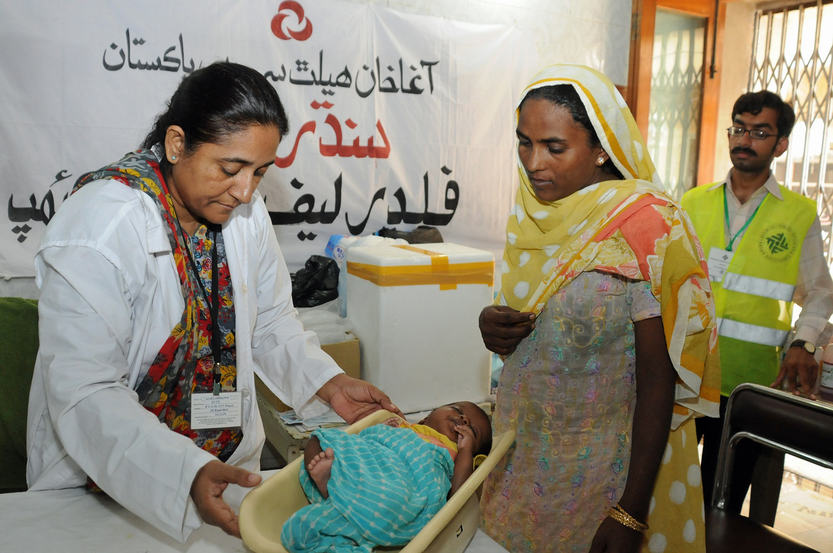 An Aga Khan Health Service doctor examines an infant at a FOCUS relief camp in Hyderabad, Pakistan. Photo: Ismaili Council for Pakistan / Al Jaleel