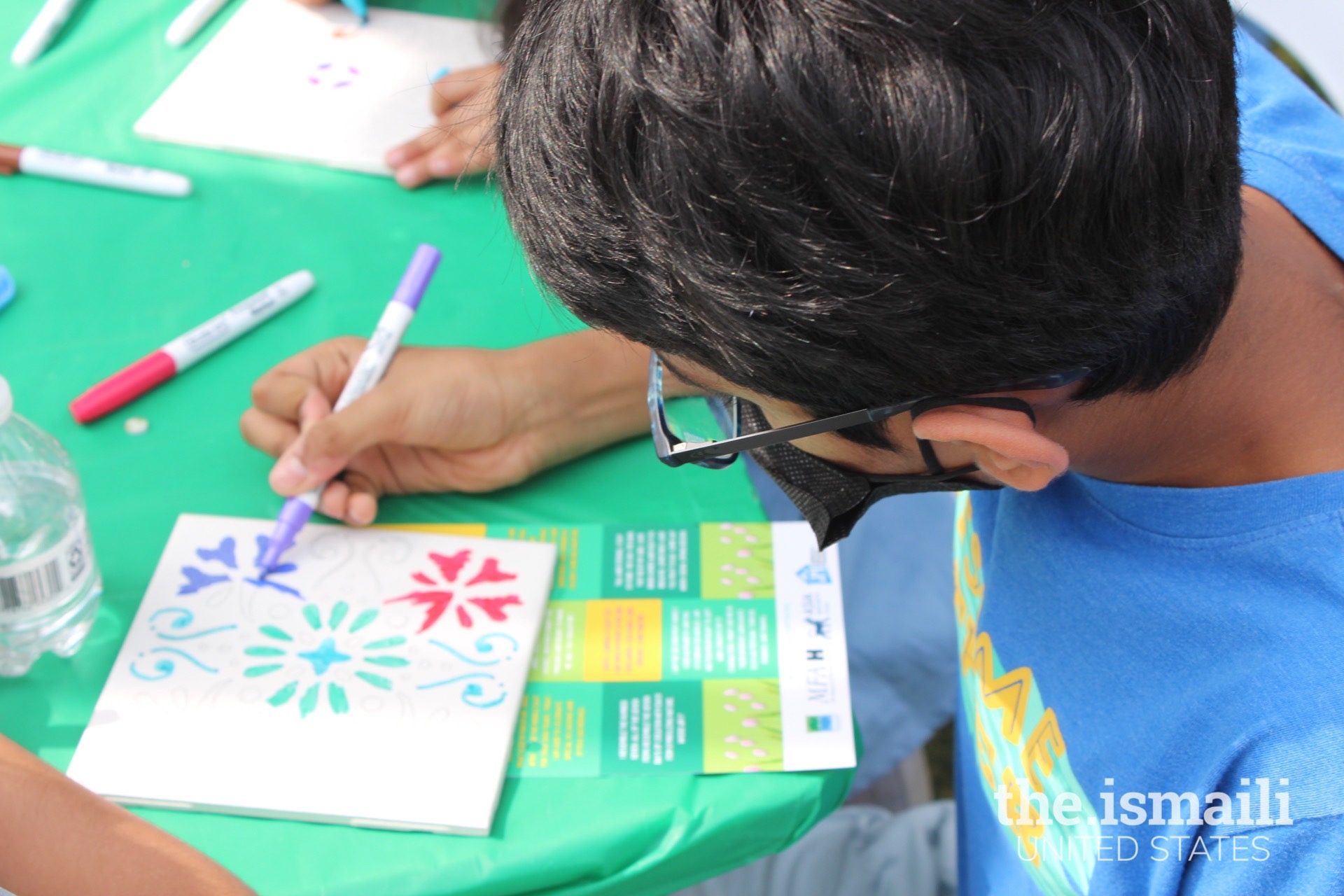 Tile-designing activity using a traditional Persian stencil at the New Year’s Gems arts and crafts booth.