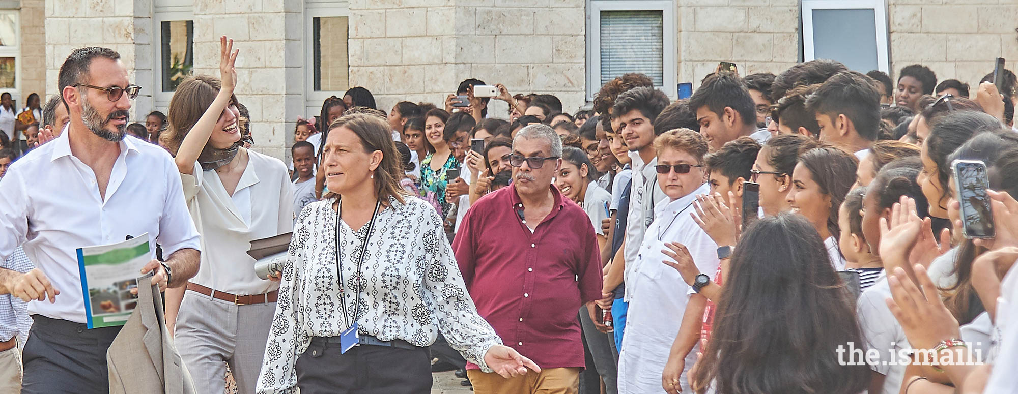 Prince Rahim and Princess Salwa, accompanied by the Head of the Aga Khan Academy Mombasa, Ms Alison Hampshire, wave goodbye to students and parents upon their departure from the school. 