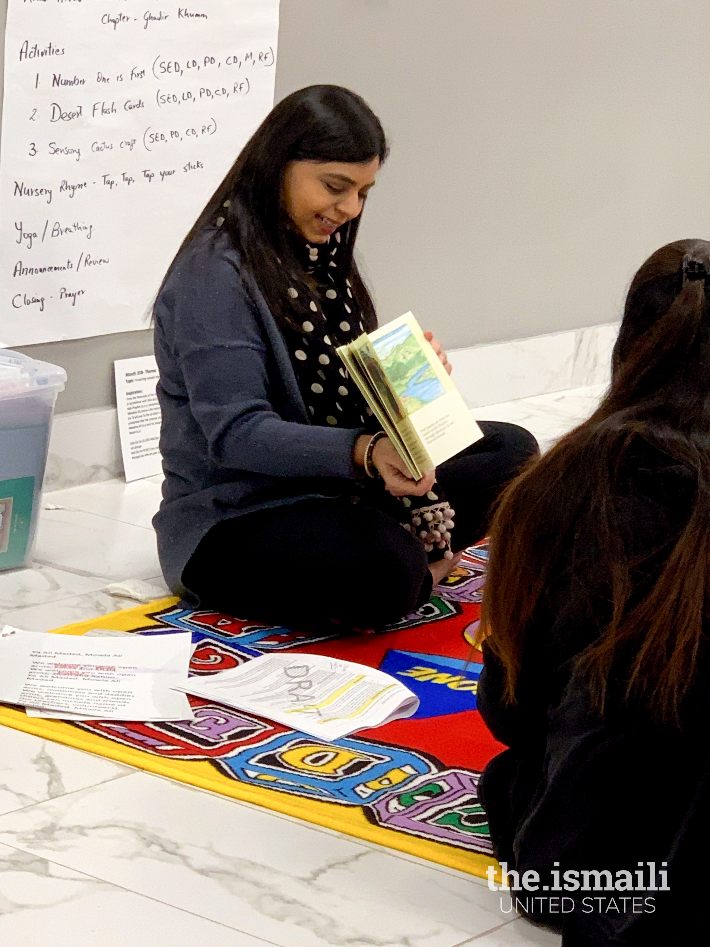 Noureen leads an ECD class with a children's book.