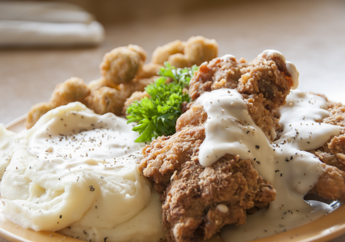 Southern comfort food at its best - mashed potatoes with country fried chicken and gravy on top.