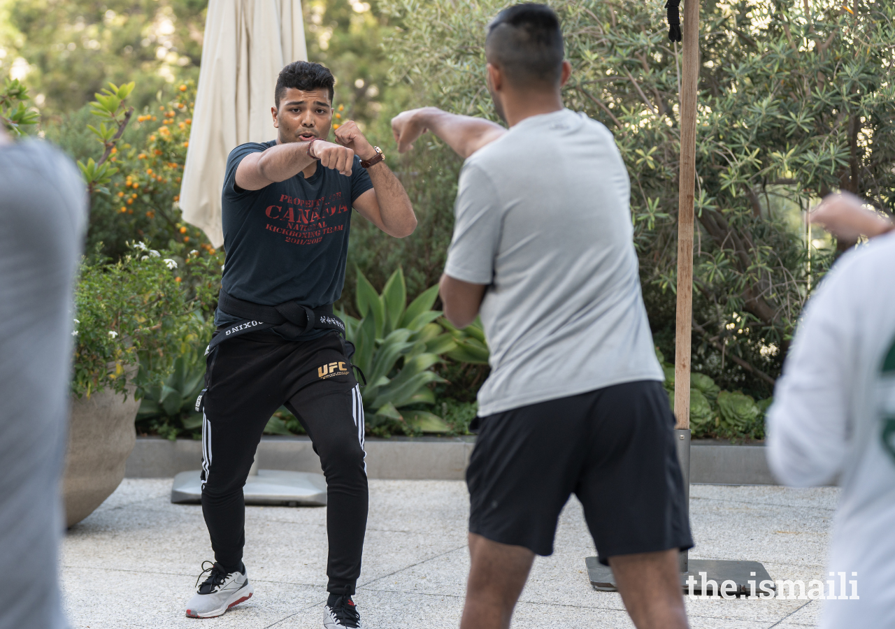 Three-time world jiu-jitsu champion Moiz Lakhani instructing a kickboxing class for participants.