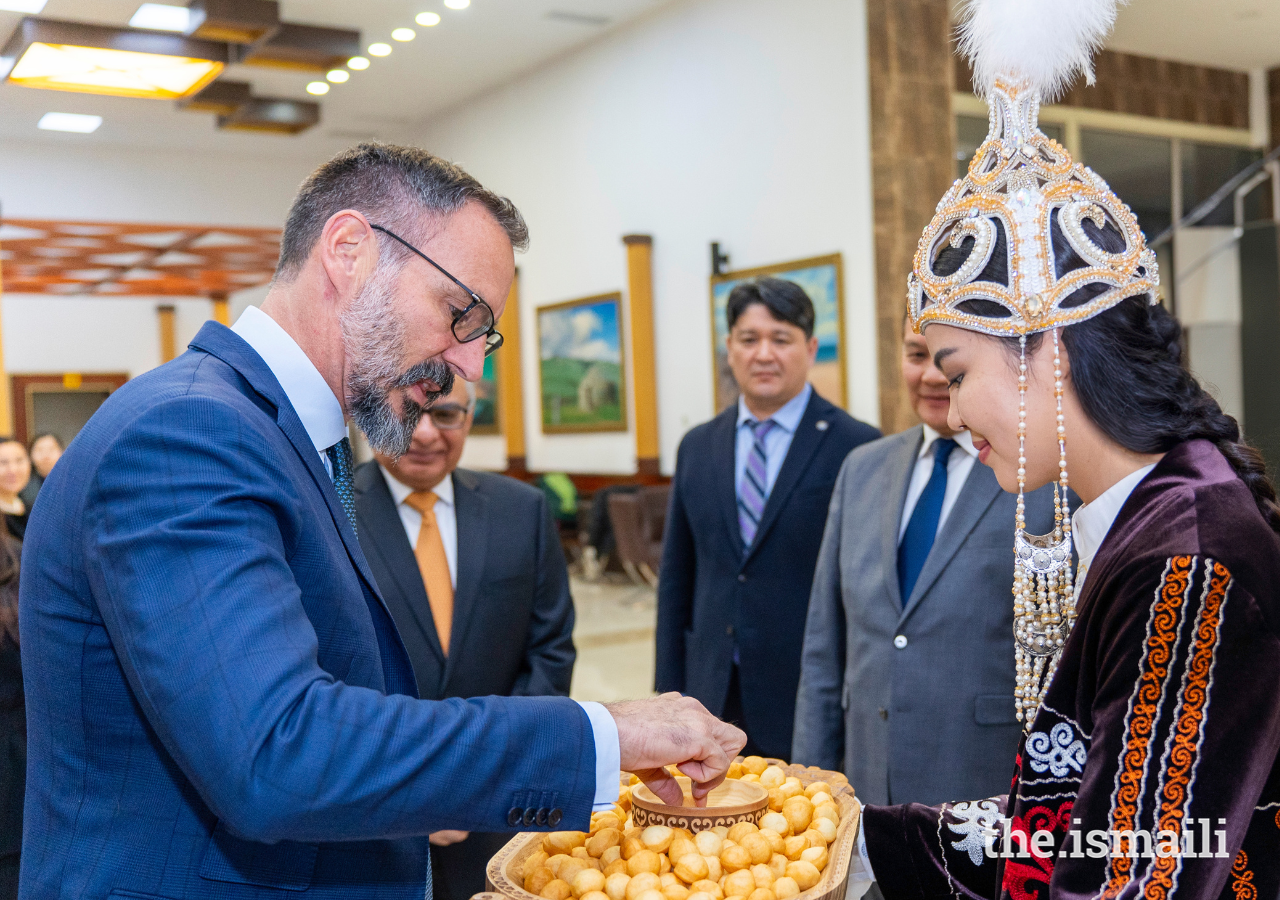 Prince Rahim samples boorsok and honey, a traditional Kyrgyz delicacy offered to guests.