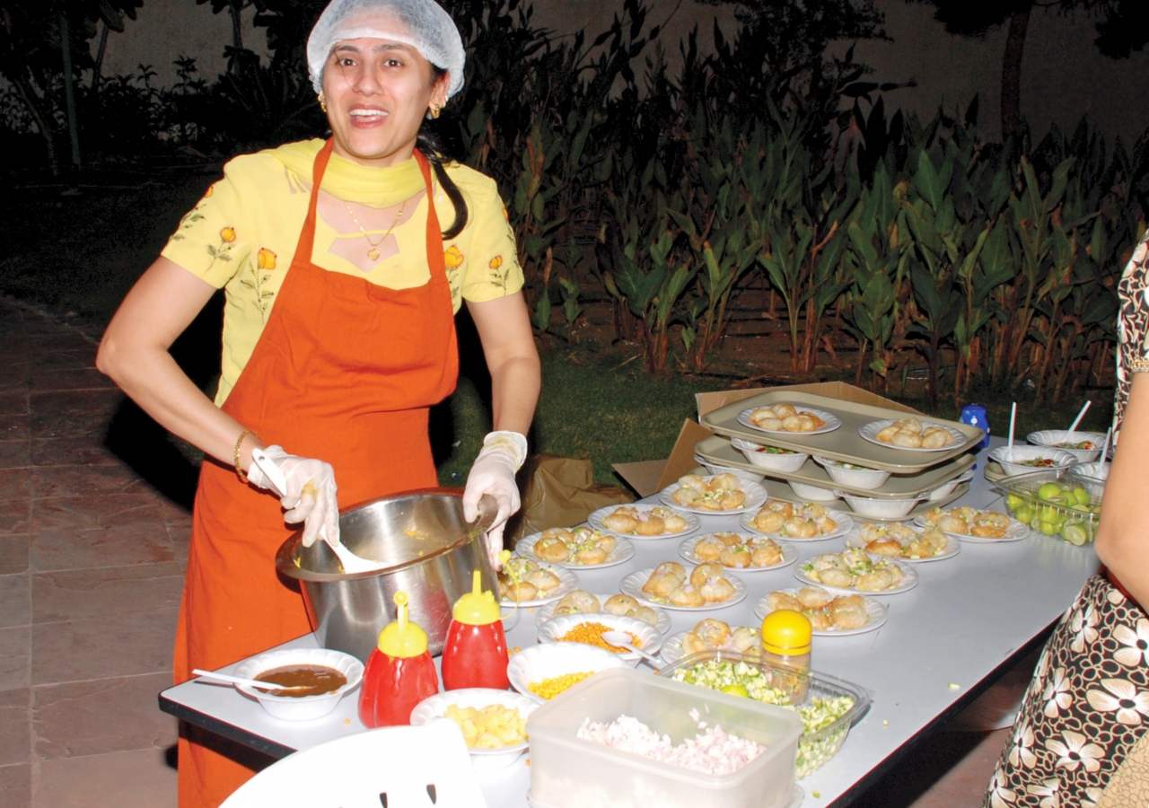 A volunteer prepares Dhai Puri (yogurt and puri) at the Golden Alliance food mela.