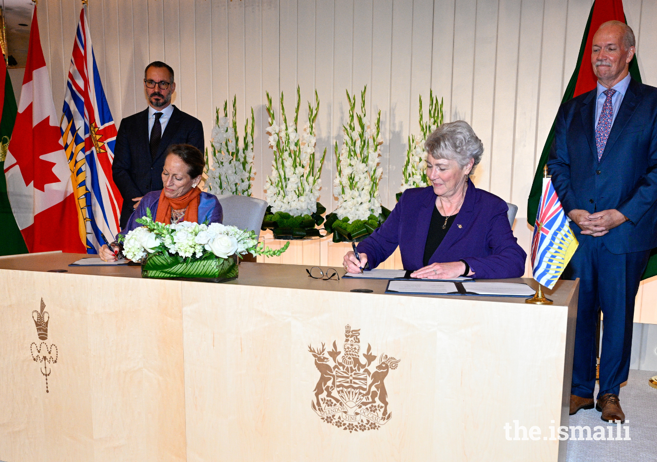 Princess Zahra and British Columbia Minister of Forests Katrine Conroy sign a climate adaptation agreement to address growing global challenges around the environment and climate, as Prince Rahim and Premier John Horgan look on.