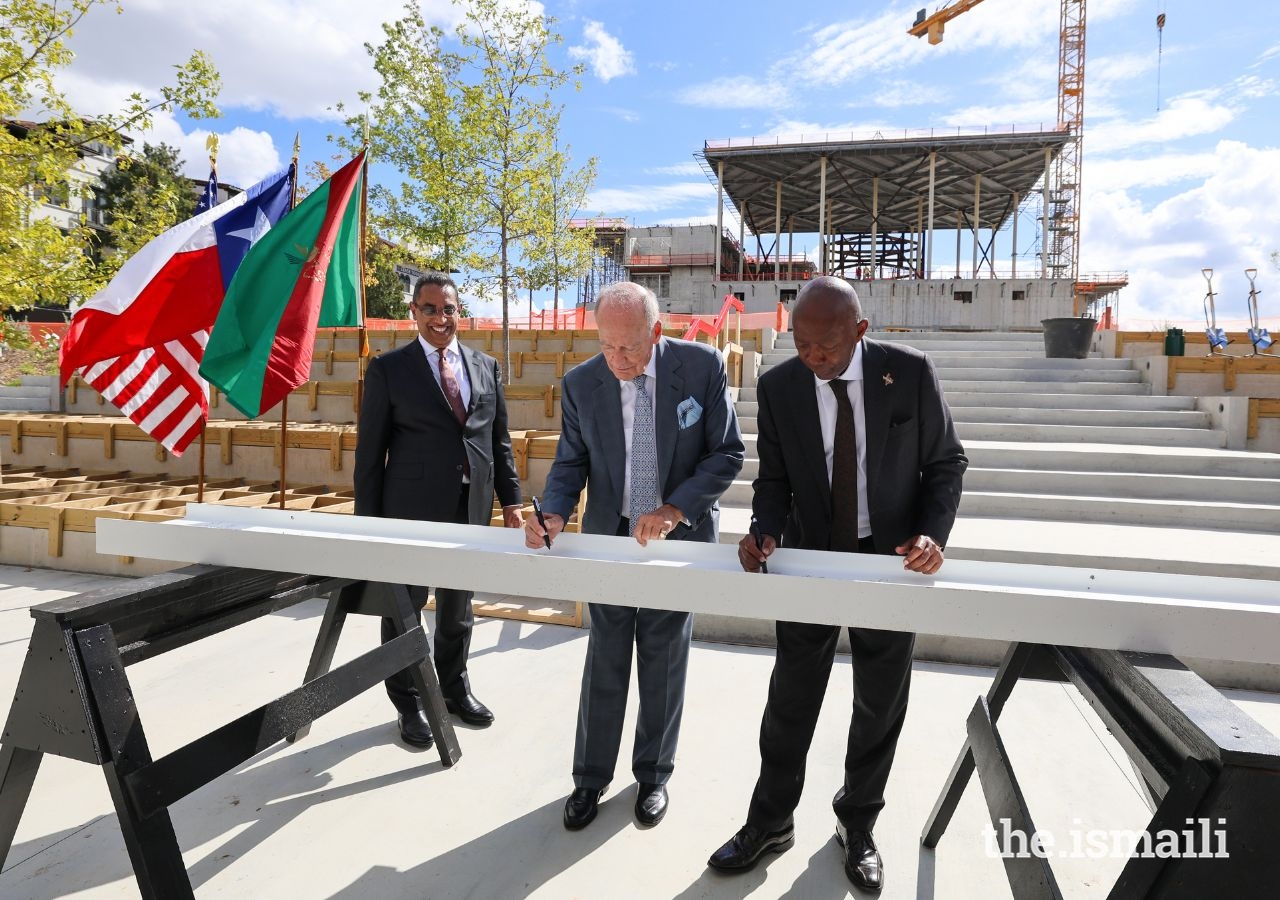 Prince Amyn and Mayor Turner sign the final beam that will complete the superstructure of the Ismaili Center.