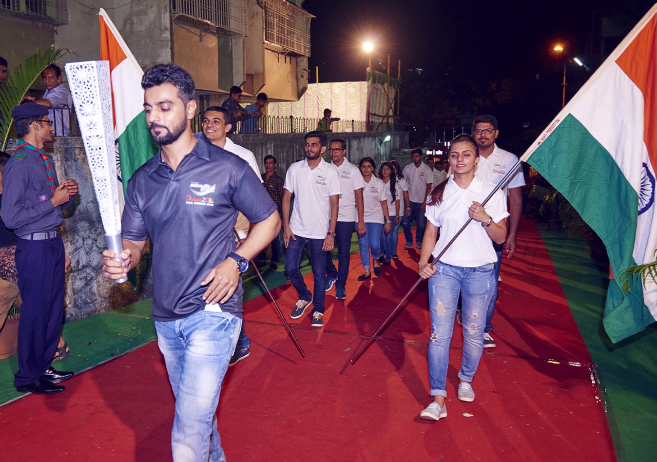 Athletes bearing the Indian flag follow the Jubilee Games Fanous at a ceremony in Mumbai. Shams Maredia