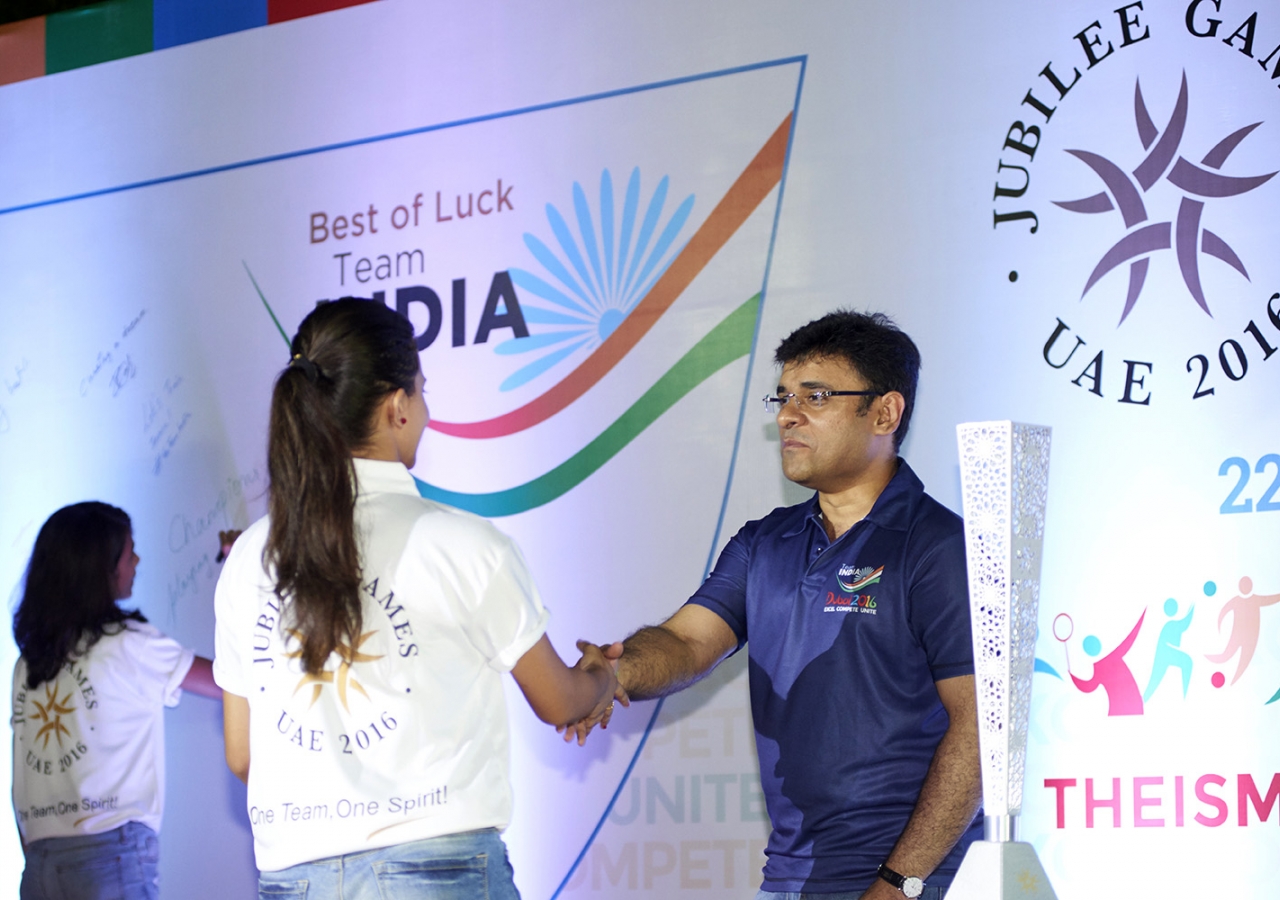 Indian athletes receive congratulations from Ismaili Council Vice-President Munir Merchant as they ascend the stage to sign the wall. Shams Maredia