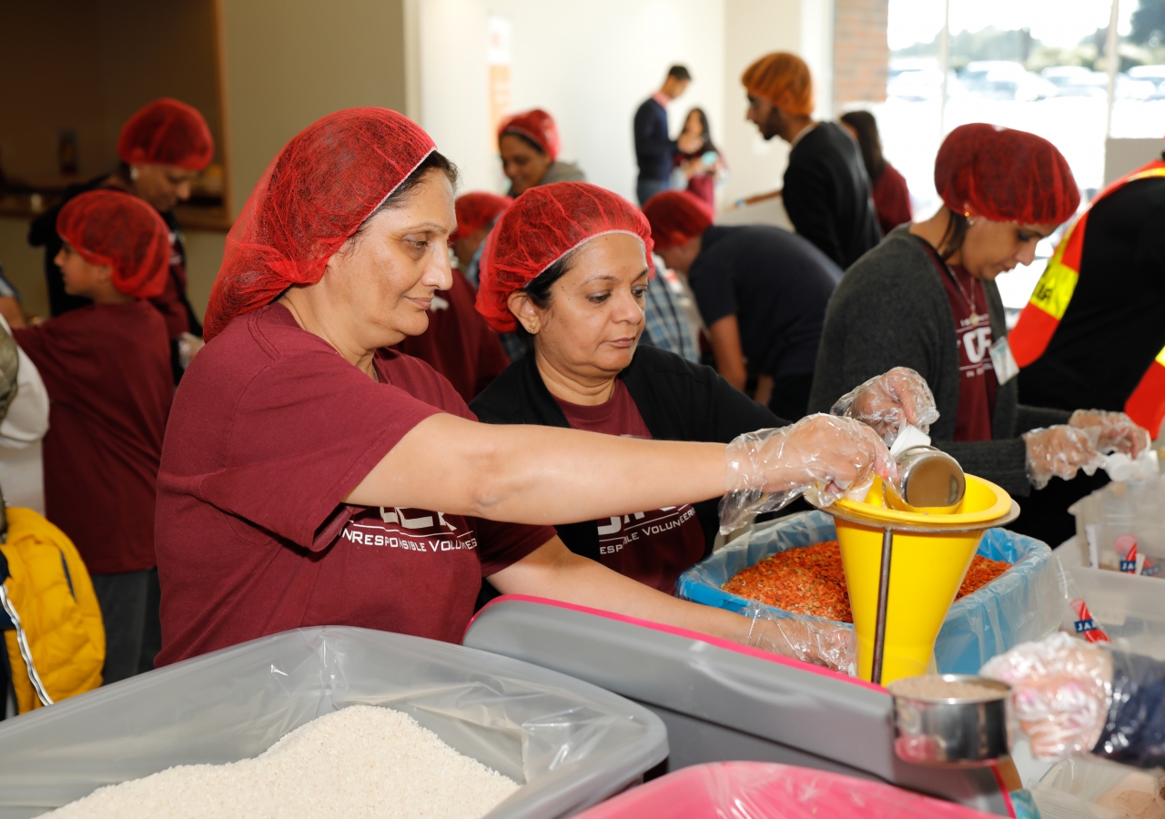 I-CERV volunteers carefully measure dry ingredients for jambalaya at the 60 for 60 event.