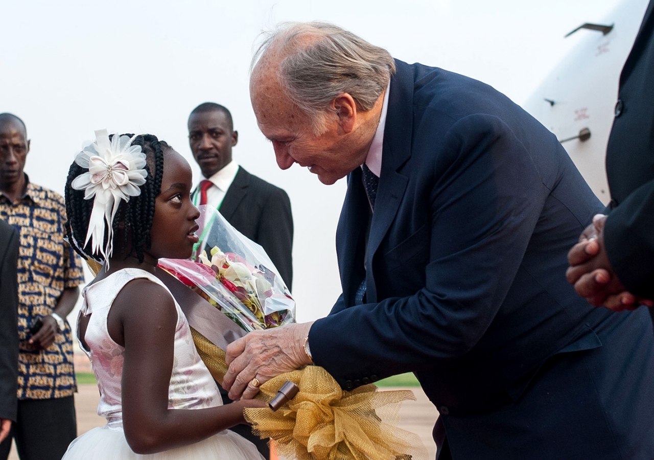 A six-year-old girl presents flowers to Mawlana Hazar Imam as he steps off the plane at Entebbe. AKDN / Will Boase