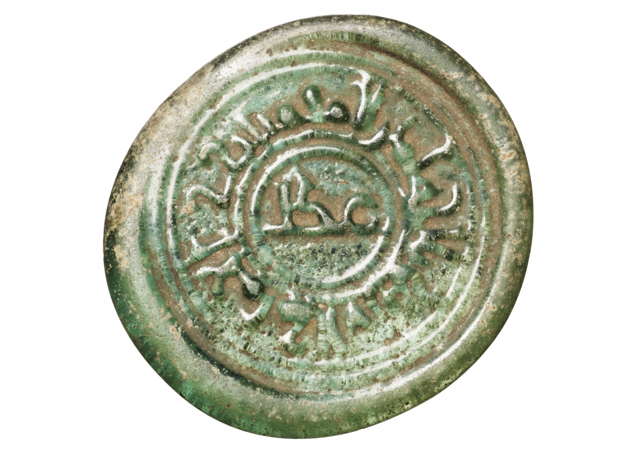 The outer marginal inscription reads al-Imam al-‘Aziz bi’llah amir al-mu’minin, and the inner circle contains the word ‘adl.