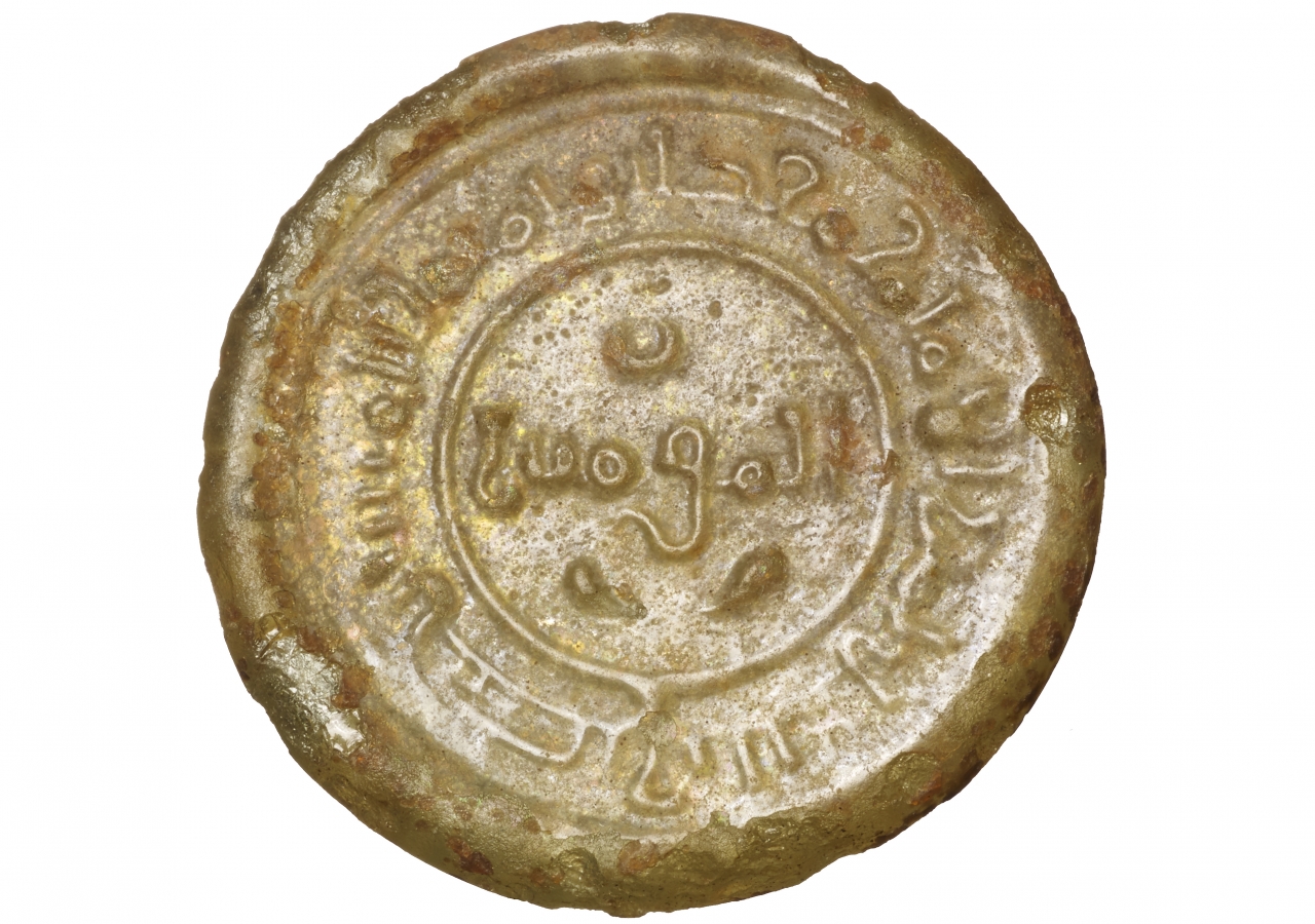 The inscription in the circular plain border, reads al-Imam Ma‘ad Abu Tamim al-Mustansir bi’llah amir. The inscription in the center reads, al-mu’minin. On the reverse, a partial date most likely refers to AH 439 (1047-48 CE). 