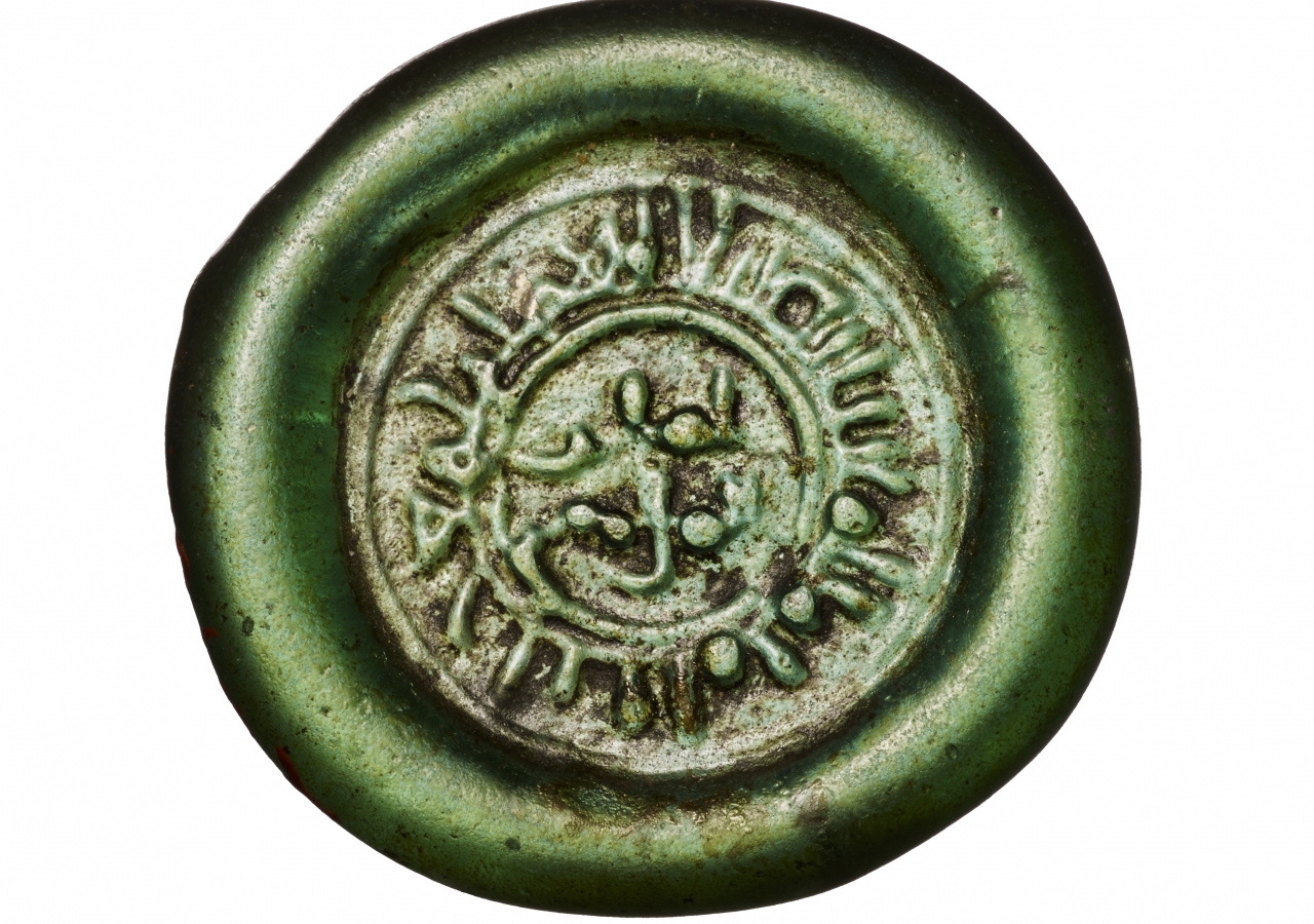 The marginal inscription reads al-Imam Ma‘ad Abu Tamim al-Mustansir bi’llah, and the center field contains a two-line inscription, amir al-mu’minin.