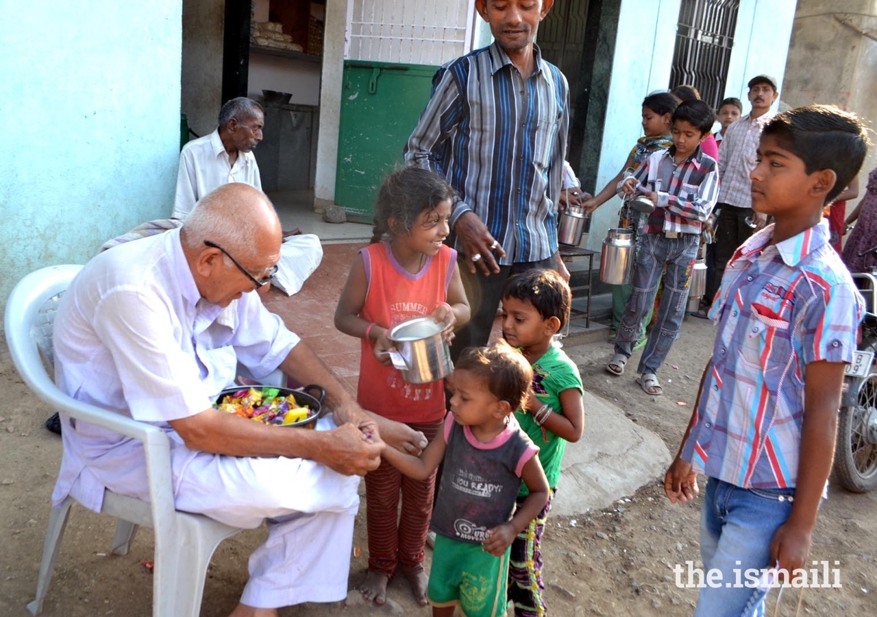 Amirbhai Lalani distributes sweets to disadvantaged children in Northern Saurashtra, India.