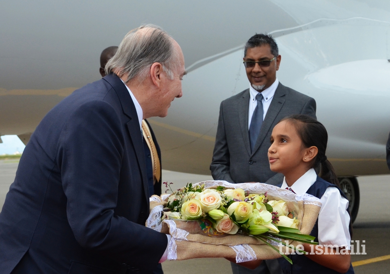 Upon arriving in Nairobi, Mawlana Hazar Imam is presented with a bouquet of flowers by Umaiza Jamal, a young member of the Ismaili Volunteer Corps.
