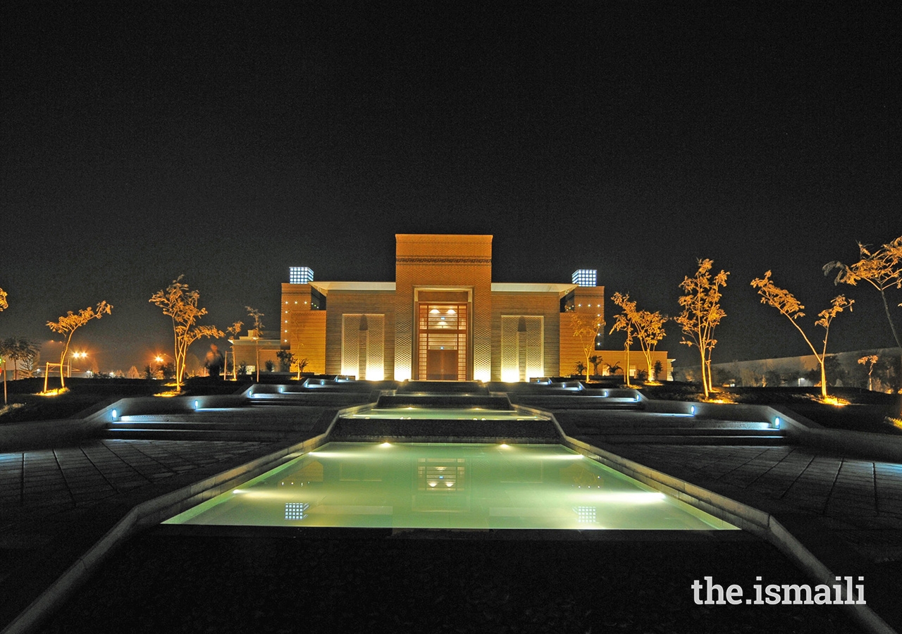 An evening view of the Ismaili Centre, Dushanbe. Pedestrian walkways line the cascading water feature, leading to the building’s main entrance.