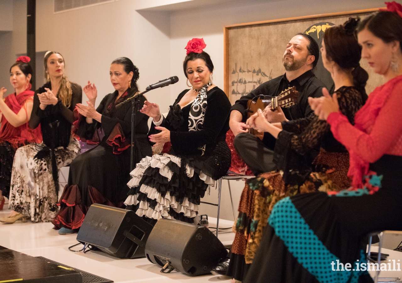 Irma La Paloma singing, while other performers accompany her with palmas (clapping)