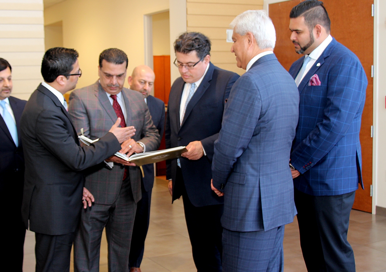 Texas Secretary of State Rolando B. Pablos looking over the Golden Jubilee book with Ismaili Council for Central USA President Nizar Didarali and Ismaili Council for Southwestern USA President Murad Ajani.