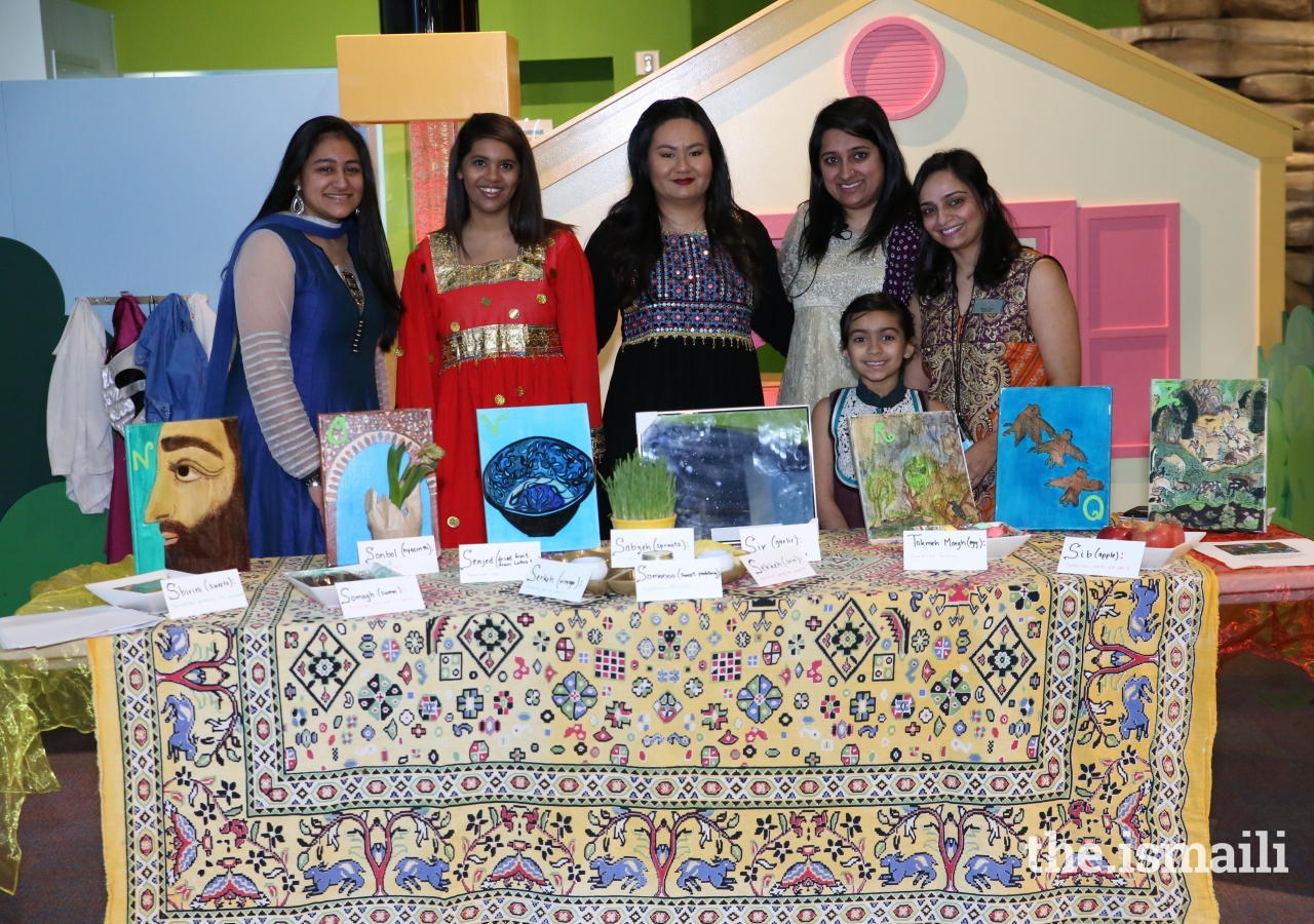 Museum’s Outreach Educator, Nissa Kara and her daughter Ariana Ali pose for a picture at the Haft-seen table decorated with painting by Shalina Chranya from AKM book, Astounding ABC.