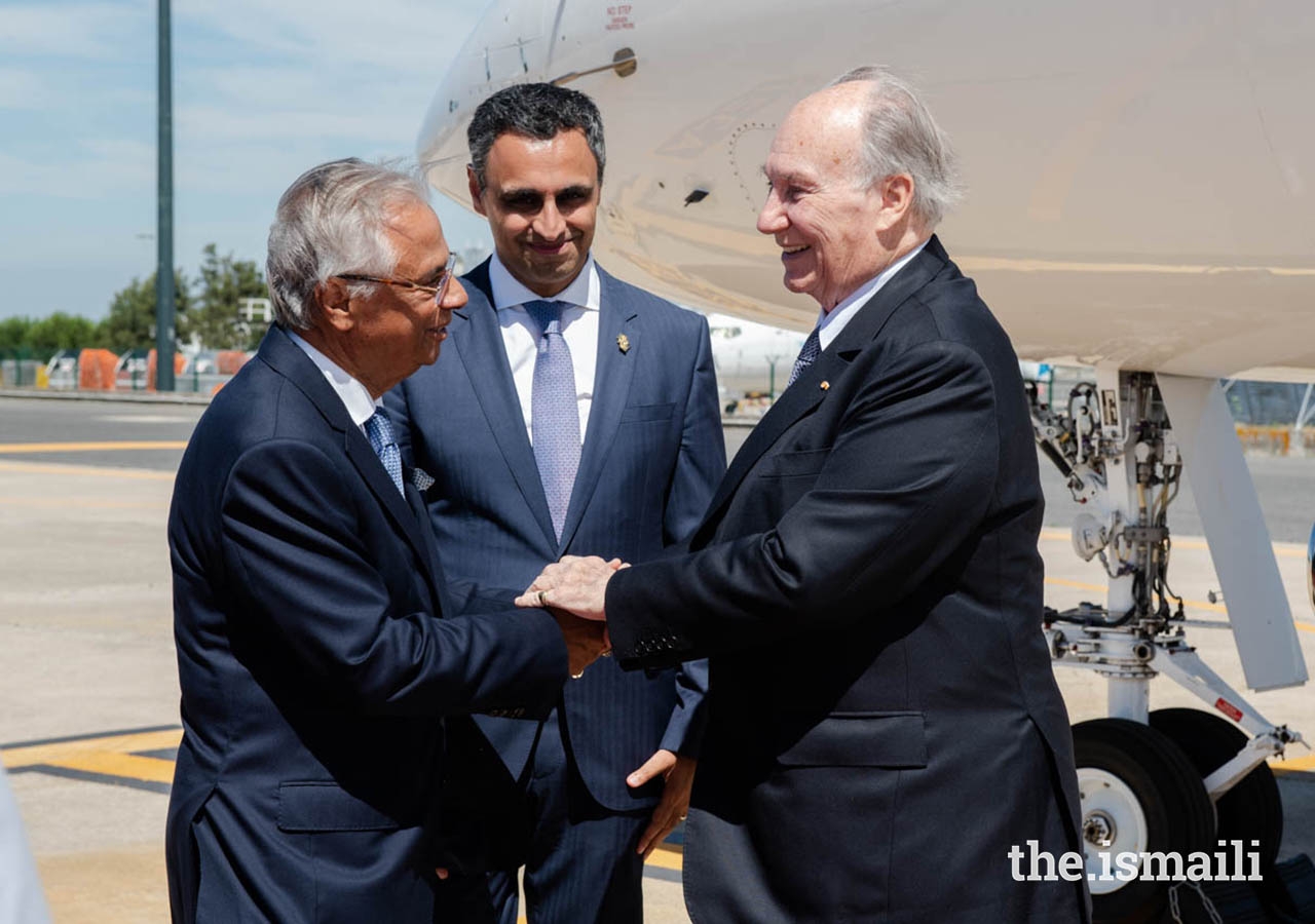 Mawlana Hazar Imam is greeted by Nazim Ahmad, Diplomatic Representative of the Ismaili Imamat to the Portuguese Republic, as Rahim Firozali, President of the Ismaili Council for Portugal looks on.