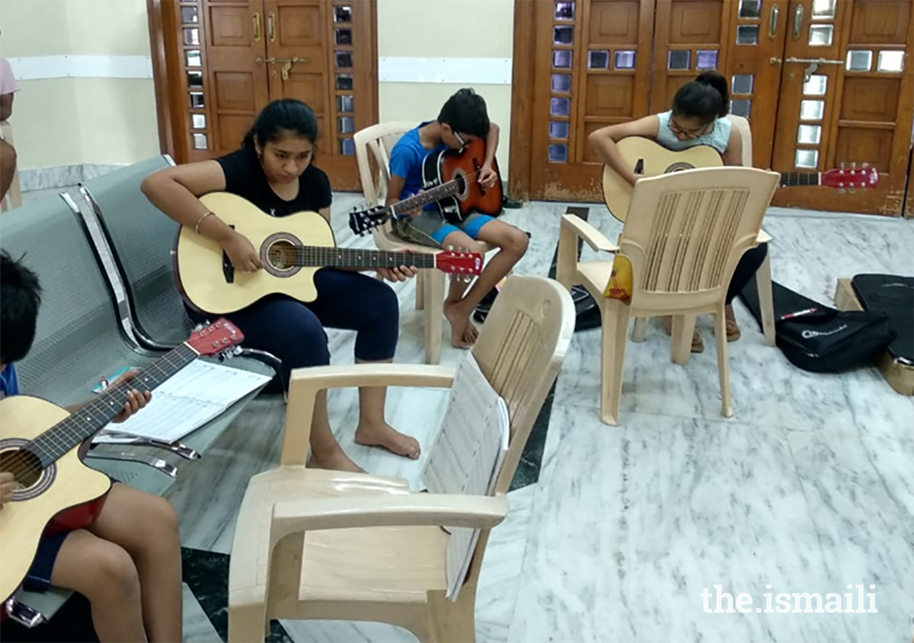 Participants learning the guitar at AKYSB’s Music Matters programme. Studies have shown that Art education, including musical education, helps in brain development and promotion of multiple intelligences in children.