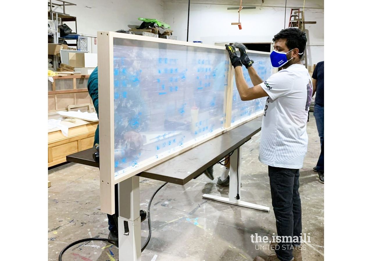 A volunteer in the Southwest region working on a new plexiglass installation for the Jamat's safety.