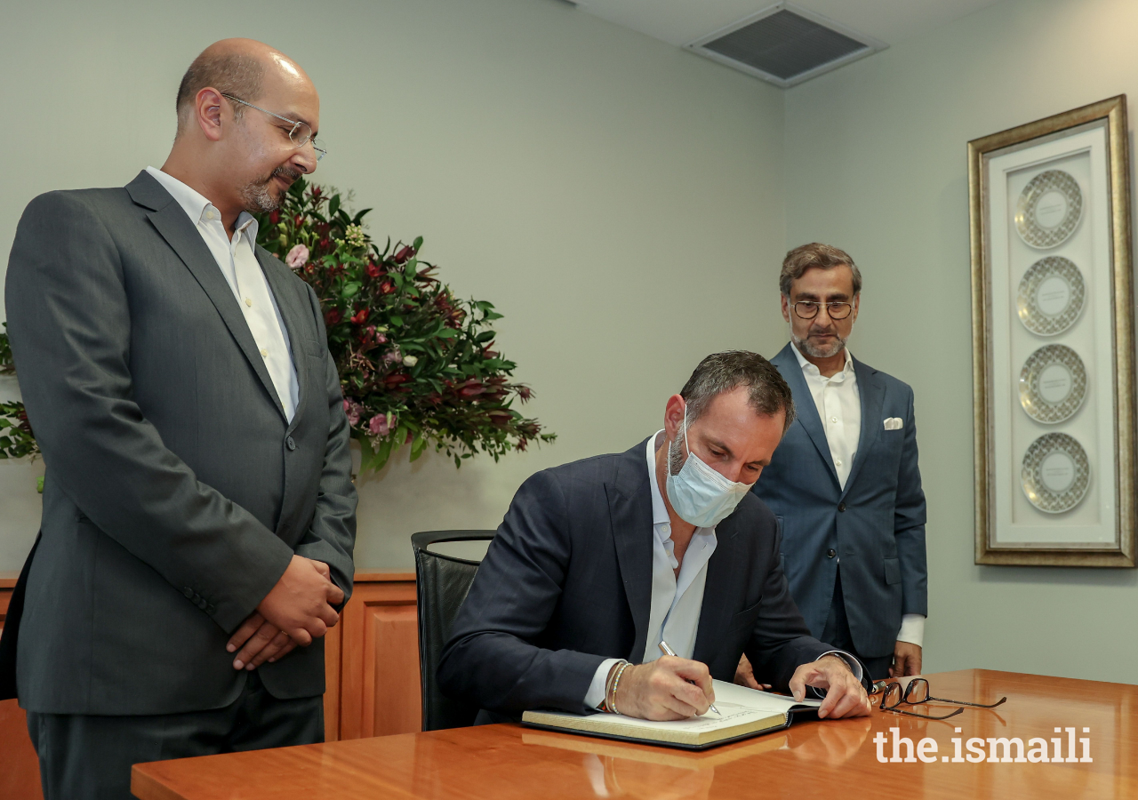 Prince Rahim signs the guest book at Maputo Jamatkhana, as the President and Vice-President of the Ismaili Council for Mozambique look on.