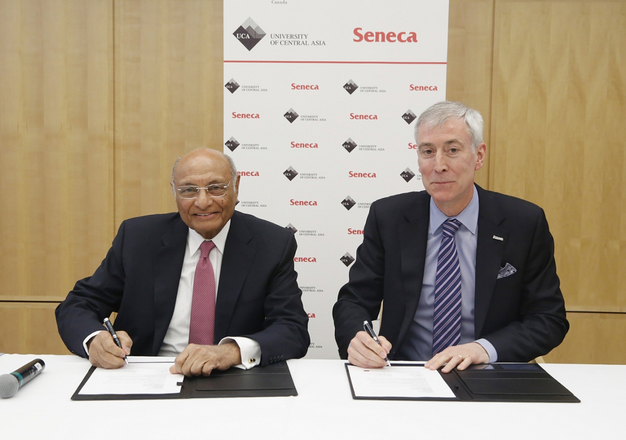 Shamsh Kassim-Lakha and David Agnew representing the University of Central Asia and Seneca College respectfully, reaffirm their partnership with a signing ceremony in Ottawa. AKFC / Patrick Doyle