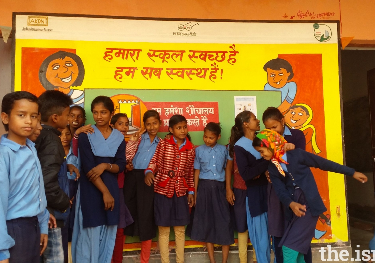 School Children in Prakhand posing in front of a clean School poster.