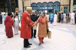 A senior Jamati leader, in ceremonial regalia, welcoming Jamati members in London 