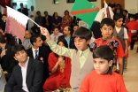 Children parade into the hall waving the Qatari and Ismaili flags.