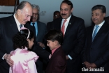Mawlana Hazar Imam in a light moment with children presenting bouquets.