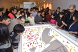 Visitors gather around the architectural-scale model of a historic district of Cairo that served as a centrepiece of the exhibition and was populated by houses designed and printed by 3D workshop participants. Vazir Karsan