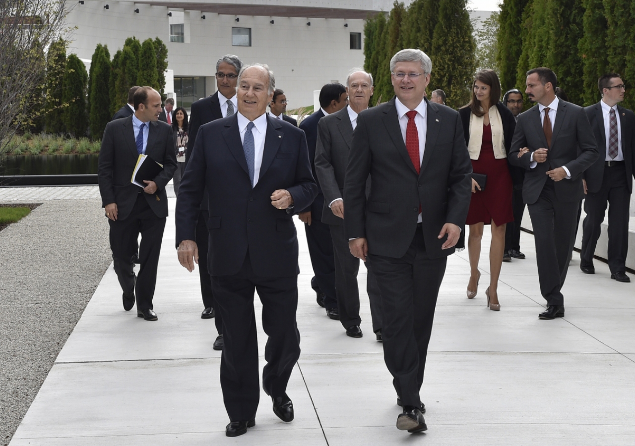 Mawlana Hazar Imam and Prime Minister Harper walk through the park together with members of the Imam&#039;s family and institutional leaders. Gary Otte
