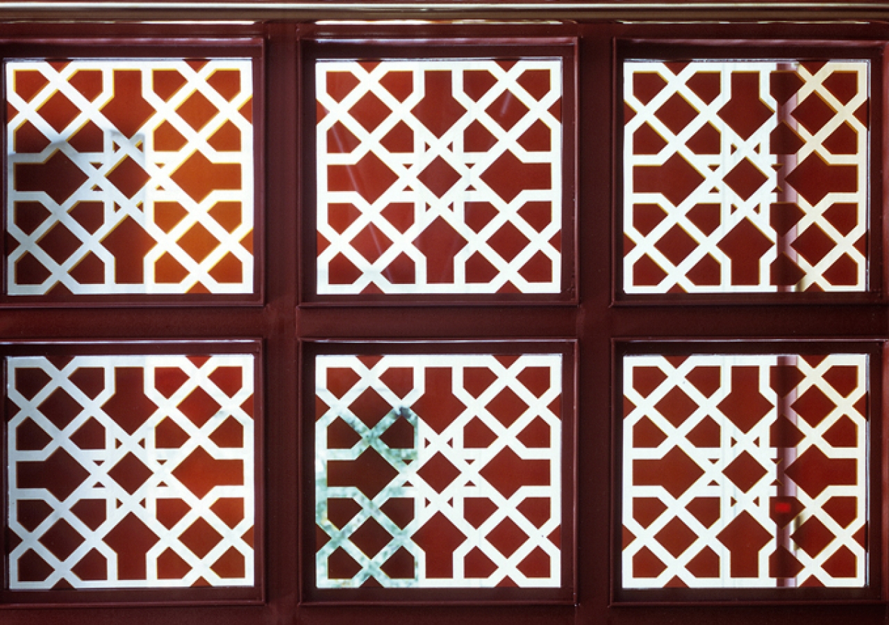 A detailed view of the window pane reveals intricate Islamic geometric patterns.