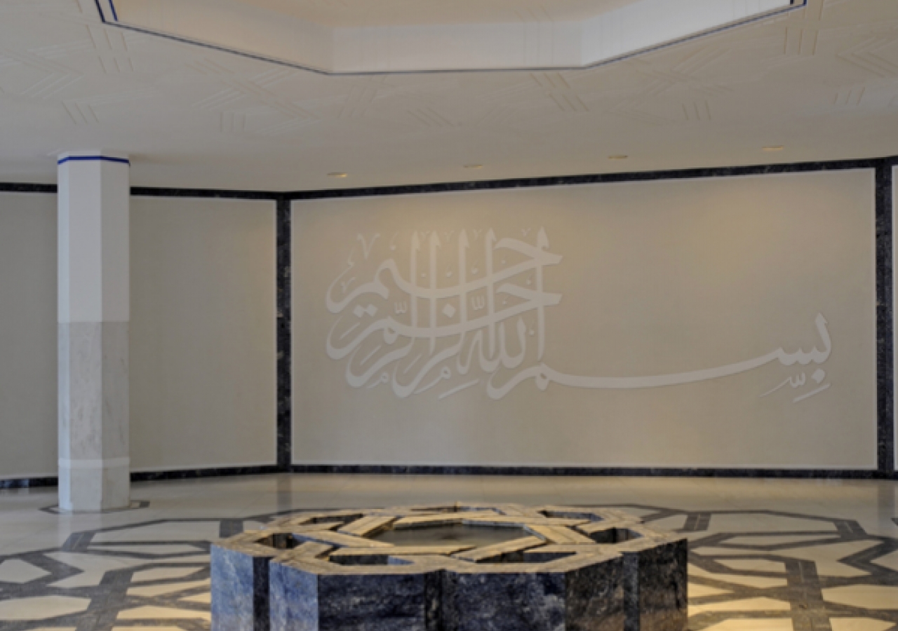 The fountain pool in the Entrance Hall follows the inter-weaving geometrical floor pattern, characteristic of Islamic art, executed in white marble, Brazilian blue granite and inlaid stainless steel. The calligraphic Basmallah adorns the far wall.