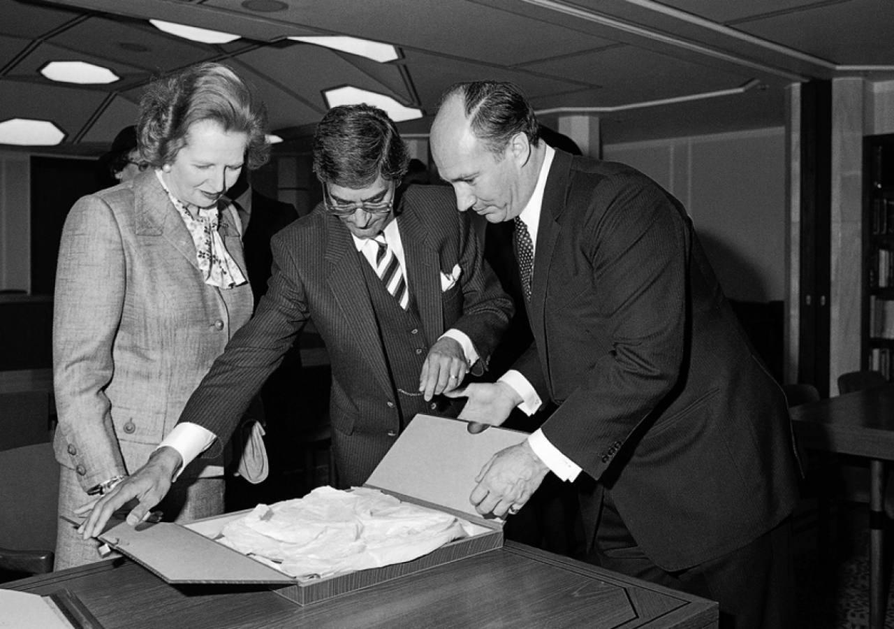 Mawlana Hazar Imam, Prime Minister Thatcher and Anil Ishani, President of the Ismaili Council for the United Kingdom, unpack a gift at the occasion of the opening of the Ismaili Centre, London.