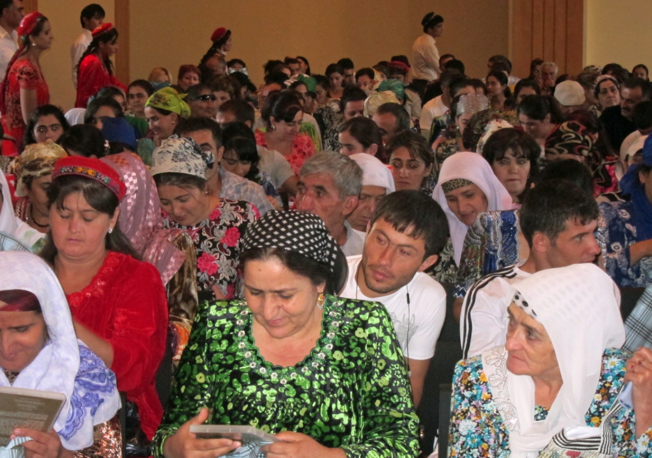 Members of the Jamat receiving Eid gifts, including Ismaili Centre, Dushanbe commemorative pins.