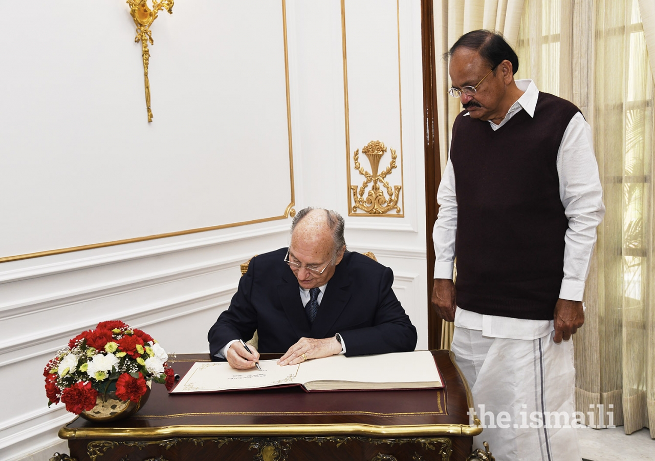 Mawlana Hazar Imam signs the visitors book at the Hyderabad House in New Delhi as Vice President Shri M. Venkaiah Naidu looks on.