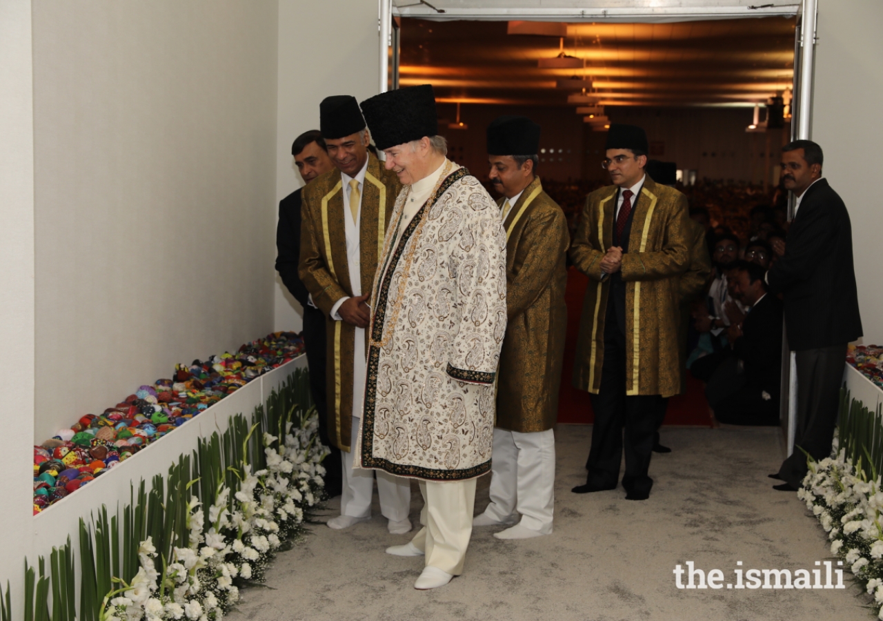 After exiting the Darbar hall, Mawlana Hazar Imam stops to observe artwork created by young students for the occasion of his Diamond Jubilee visit to India.