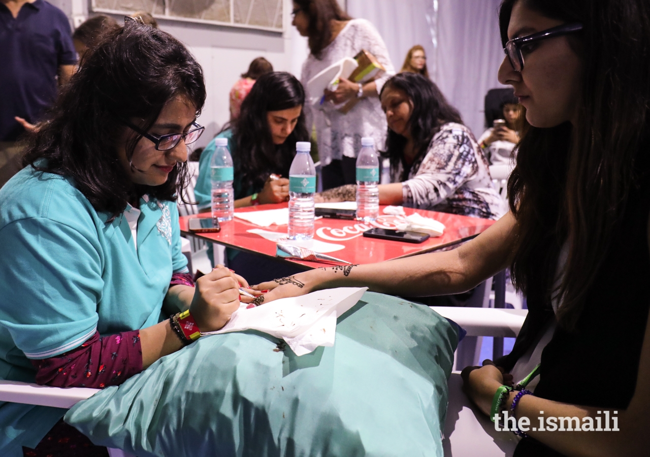 Artistic volunteers applied mehndi for Jamati members at the Pátio Mela.