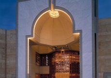 The principal entrance takes the form of a niche, emanating a lamp-like light.