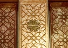 Sandblasted coral and rose marble panels inlaid with brass are used to form the mihrab, the Muslim architectural indication of the direction of prayer.