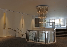 The main stairway pivots about an impressive chandelier.