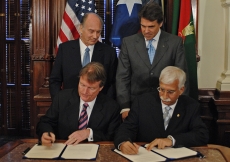 President Powers of the University of Texas and President Rasul of the Aga Khan University signing the Memorandum of Understanding at the Texas State Capitol, as Mawlana Hazar Imam and Governor Rick Perry of Texas look on. 