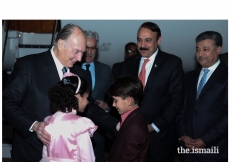 Mawlana Hazar Imam in a light moment with children presenting bouquets