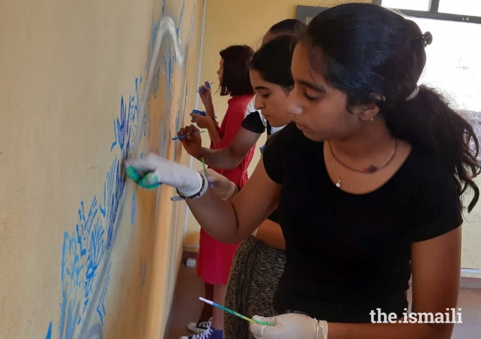 Students, and volunteer artists paint the walls of the refectory of the Magnificat Centre.