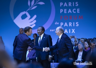 President Emmanuel Macron welcomes Mawlana Hazar Imam to the opening session of the Paris Peace Forum while President Paul Biya of Cameroon looks on.