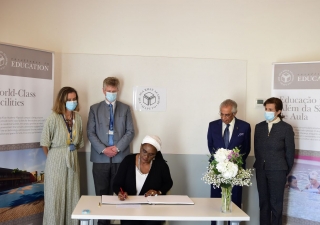The moment of signing the honor guest book by the Minister of Education and Human Development Rita Carmelita Namashulua, after the visit and meeting, in the presence of the leadership of the Aga Khan Development Network and the Aga Khan Academy