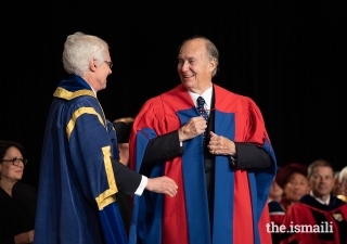 SFU President and Vice-Chancellor Andrew Petter adjusts the ceremonial SFU robe on Mawlana Hazar Imam as part of honorary degree conferral ceremony.